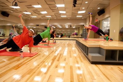 Students doing yoga in a UREC fitness studio