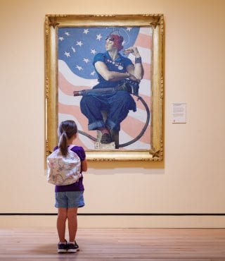 A young girl views Rosie the Riveter at Crystal Bridges Museum of American Art