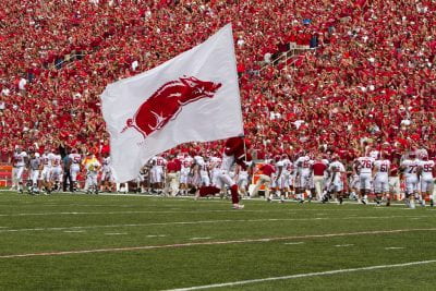 The Razorback mascot waiving a flag to a full stadium of fans